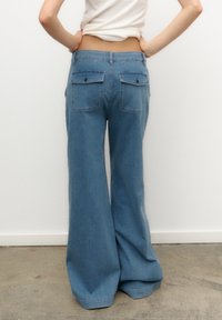 Breda jeans i ljusblå denim. Har två bakfickor och hög midja. Tyget verkar mjukt med en lätt urtvättad finish.