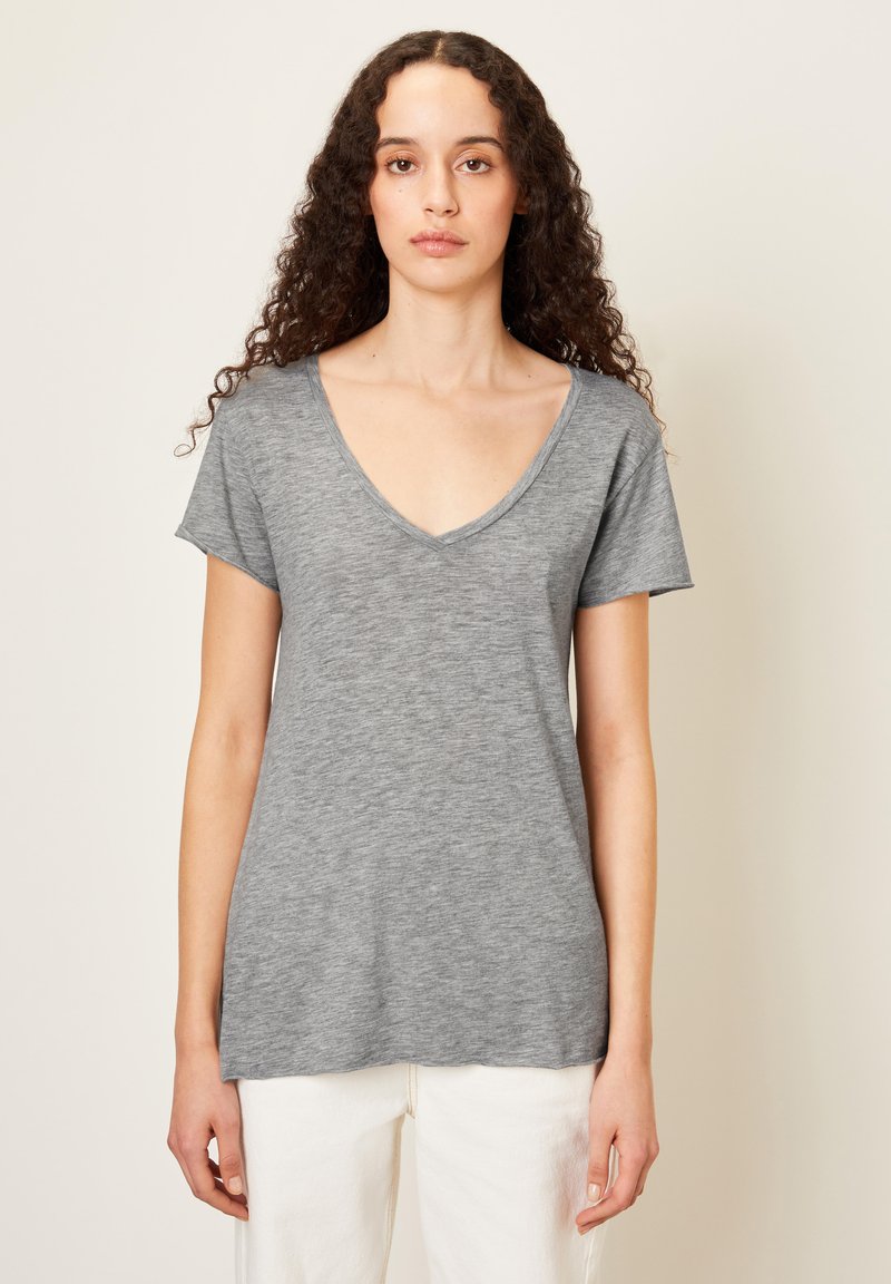 Pilkas V-kaklo marškinėliai su trumpomis rankovėmis, pagaminti iš minkštos, tekstūruotos medžiagos, pasižymintys laisvu siluetu ir tiesiu apvadu.