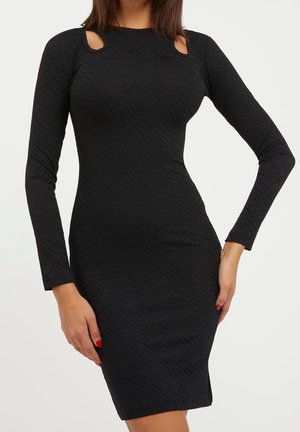 Black long-sleeve dress with a textured pattern, featuring cut-out accents at the shoulders. Form-fitting design and knee-length.