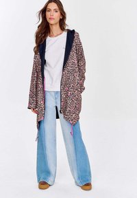 Květinová mikina s kapucí v leopardím vzoru s námořnickými akcenty, lehká látka, stahovací šňůrky, spárovaná se šedou mikinou a širokými modrými džíny.