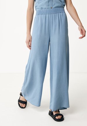 Pantalons larges bleu clair en tissu doux, avec une taille élastique et une texture lisse. Assortis avec des sandales noires.