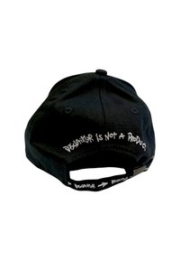 Cappellino da baseball nero con cinturino regolabile, caratterizzato dal testo "DISCLAIMER NON È UN PRODOTTO" ricamato in bianco sul retro.
