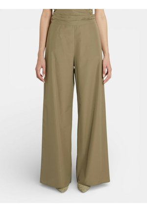 Pantaloni kaki a gamba larga con vita alta, indossati con scarpe abbinate a punta, mostrati su una persona in piedi tagliata al torso.