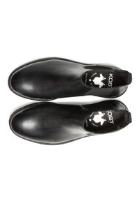Chaussures noires en cuir à enfiler avec une finition lisse, des panneaux latéraux élastiques et un design à bout rond. Dotées d'un logo de la marque à l'intérieur.