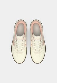 Baltos sportinės batelės su rožiniais akcentais, lygios odos viršumi, apvalia nosimi, suvarstomos raišteliais ir su tekstūruota ruda guminė pado dalimi.