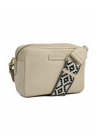 Borsa a tracolla in pelle beige con superficie texturizzata, chiusura con zip e tracolla regolabile a motivo bianco e nero. Presenta un logo sul davanti.