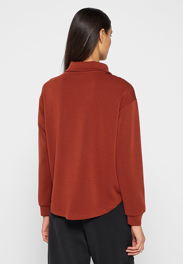 Bruine lange mouwtop met kraag, met een casual pasvorm en een gebogen zoom. Gemaakt van een gladde, zachte stof.