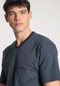 Gestreepte marineblauwe en grijze katoenen T-shirt met een V-hals, korte mouwen en een borstzak met een diagonaal streepjespatroon.