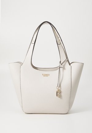 Weiße strukturierte Ledertasche mit zwei Griffen, goldenem Markenlogo und dekorativen hängenden Anhängern vorne.
