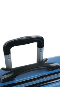 Maleta rígida azul con una superficie texturizada, que cuenta con un asa retráctil negra y un asa lateral para facilitar su manejo.