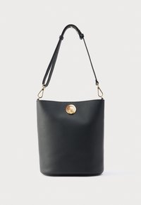 Μαύρη δερμάτινη τσάντα τύπου bucket με λείο υφή, που διαθέτει χρυσό κυκλικό κούμπωμα και ρυθμιζόμενο λουρί. Απλός και μοντέρνος σχεδιασμός.