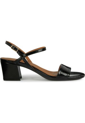 Sandale en cuir verni noir avec bout ouvert, design à brides croisées et talon carré. Présente une semelle intérieure texturée et une sangle de cheville réglable.