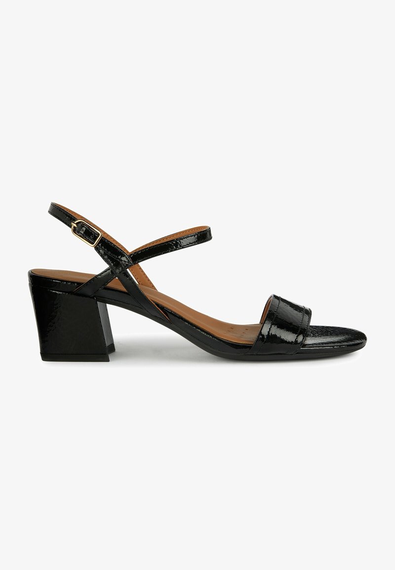 Sandale en cuir verni noir avec bout ouvert, design à brides croisées et talon carré. Présente une semelle intérieure texturée et une sangle de cheville réglable.