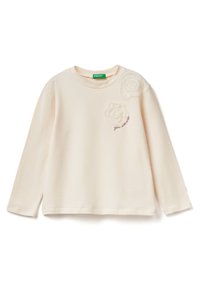 Krémové tričko s dlouhým rukávem z měkkého materiálu. Obsahuje dvě strukturované látkové aplikace ve tvaru růže a vyšívaný text "jseš skvělý" na hrudi.