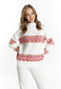 Maglione bianco lavorato a maglia con motivo a treccia, caratterizzato da un vivace motivo geometrico in rosa e giallo attorno al petto e alle maniche.