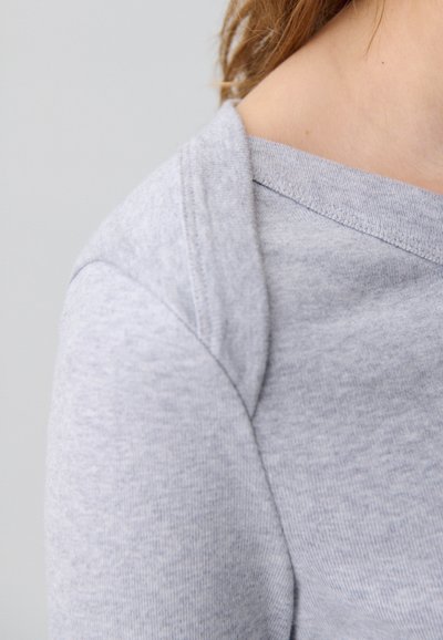 Felpa grigia in morbido tessuto, con un design leggermente scollato sulle spalle e un colletto texturizzato. Vestibilità classica e casual con dettagli minimi.