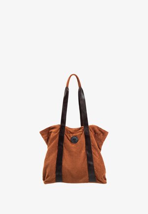 Brązowa torba tote z korduroju, z czarnymi skórzanymi uchwytami i okrąłym czarnym guzikiem na środku. Posiada luźny, miękki design.