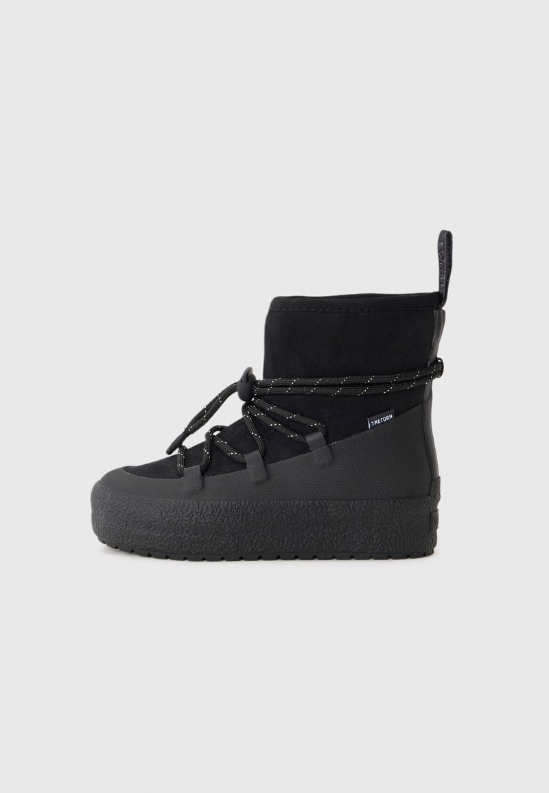 Botte d'hiver noire de hauteur moyenne avec semelle épaisse et texturée, lacets élastiques réglables, tige en tissu et languette à l'arrière.