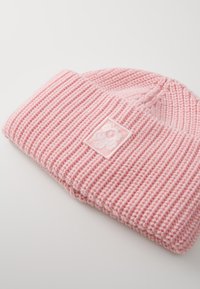 Roosa kudumüts ribakudumise tekstuuriga ja väikese broderi lillekeemiga ruudukujulisel taustal. Pehme ja mugav materjal.