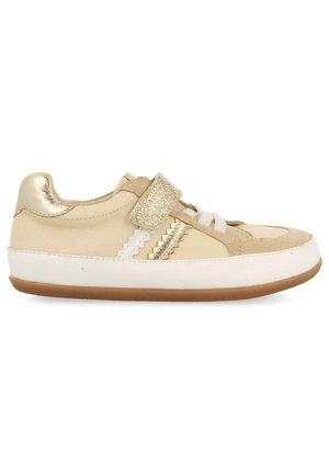 Chaussure de sport beige avec une bride pailletée dorée, tige en cuir lisse, accents en daim texturé et semelle en caoutchouc blanc avec une base marron.