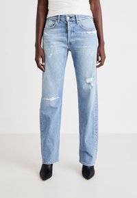 Vaqueros de denim azul claro con un corte relajado, que presentan detalles desgastados, cinco bolsillos y herrajes en tono plateado. Terminados con una pierna recta.