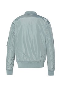 Lichtblauwe bomberjack, glanzend nylon materiaal, ribbelkraag en -manchetten, elastische tailleband en lichte padding zichtbaar op de mouwen.