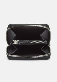 Zamknięty czarny skórzany portfel, otwarty, przedstawiający srebrny zamek błyskawiczny oraz wiele przegród na karty i monety.