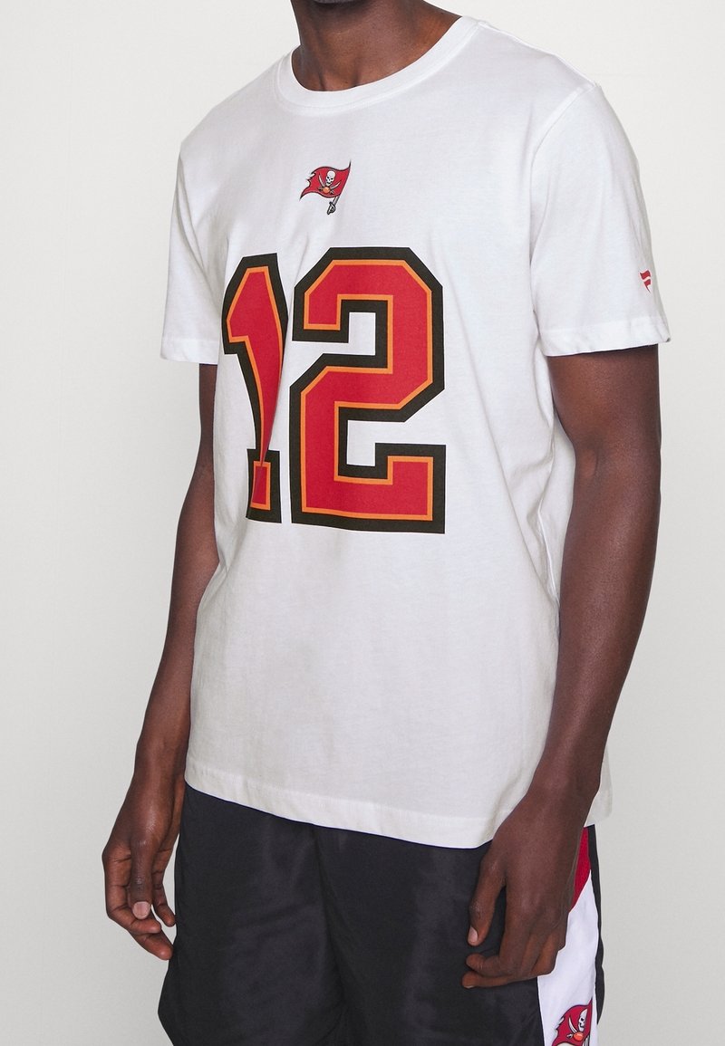 Bílý bavlněný tričko s červeným a černým designem čísla "12" a malým logem Tampa Bay Buccaneers na hrudi. Krátké rukávy, kulatý výstřih.