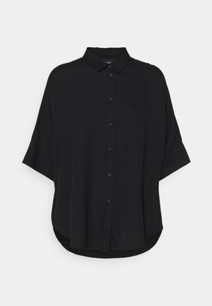 Sort oversize skjorte med korte ærmer og krave, vist på en ensfarvet baggrund.