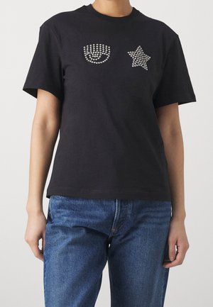 T-shirt en coton noir avec des accents en strass en forme de visage souriant et d'étoile, doté d'un col rond classique et de manches courtes.
