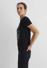 Black short-sleeve t-shirt featuring a colorful floral graphic design on the front. Made of soft cotton with a relaxed fit.