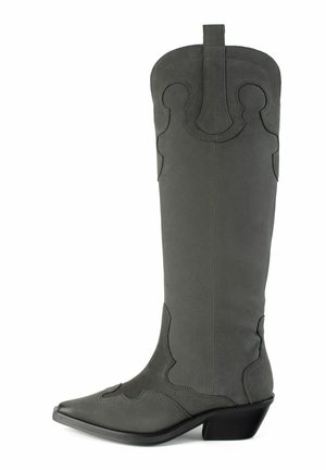 Grå ruskinds western-stil støvle med høj skaft, spids tå, dekorativ syning og en lav stablet hæl. Har en håndtagsrem i toppen.