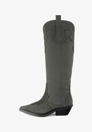 Grå ruskinds western-stil støvle med høj skaft, spids tå, dekorativ syning og en lav stablet hæl. Har en håndtagsrem i toppen.