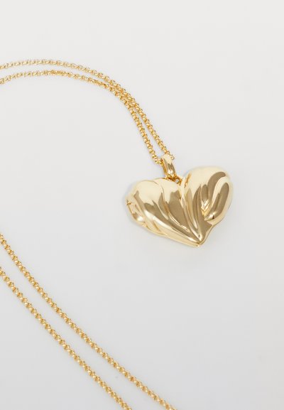 Collana con pendente a cuore dorato con una superficie texture, caratterizzato da design fluido. Pende da una delicata catena d'oro intrecciata.