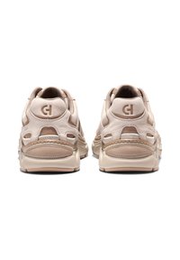 Sneaker beige con finitura in pelle texture, dotate di un design curvo, cuciture a contrasto e dettagli a taglio sul tallone. Suola leggera.