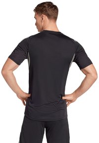 Zwarte atletische shirt met korte mouwen, met een gladde textuur en grijze zijaccenten, voorzien van een ronde hals en een getailleerde pasvorm.