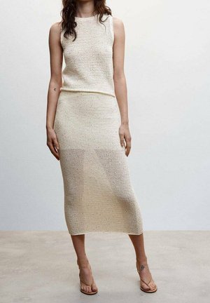 Strick-Zweiteiler in Creme, bestehend aus einem ärmellosen Oberteil und einem knielangen Rock mit einem strukturierten Muster und einer figurbetonten Silhouette.