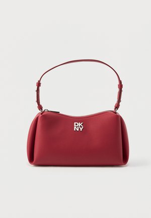 Sac à bandoulière DKNY en cuir rouge avec logo argenté, fermeture éclair incurvée sur le dessus et sangle réglable sur fond uni.
