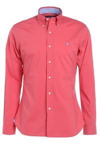 Košile na knoflíky v korálově růžové barvě z bavlny s modrým vnitřním límcem. Má dlouhé rukávy a malé vyšívané logo na hrudi.