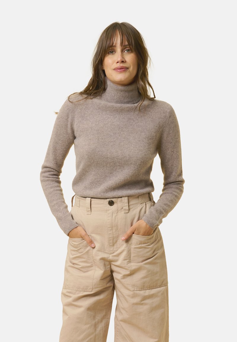 Helles braunes Turtleneck-Sweatshirt aus weichem Wollstoff, figurbetonte Silhouette. Kombiniert mit beigen, hoch taillierten Cargo-Hosen mit großen Taschen.