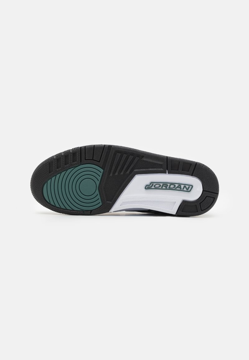 Semelle en caoutchouc noir avec accent circulaire vert, semelle intermédiaire blanche, motifs texturés et logo "JORDAN" en vert sur le côté.