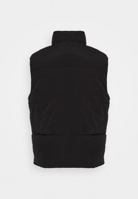 Schwarze ärmellose Steppweste mit hohem Kragen, die ein gestepptes Design und eine glatte Textur aufweist, bietet einen modernen und funktionalen Look.