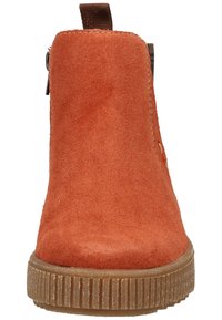 Bottine en daim couleur rouille avec languette marron et semelle épaisse en caoutchouc texturée, vue de face.