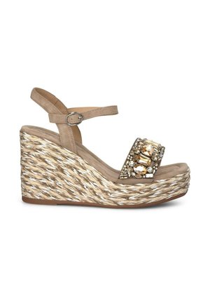 Wedge sandal with a beige suede upper, braided jute platform, and embellished strap featuring clear and amber stones. Adjustable ankle strap.