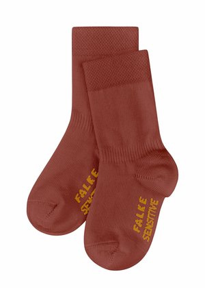 Rostfarbene Knöchelsocken mit geripptem Bündchen, glatter Textur und gelb gedrucktem Text "FALKE SENSITIVE" an der Seite.