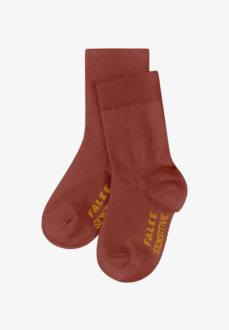 Rostfarbene Knöchelsocken mit geripptem Bündchen, glatter Textur und gelb gedrucktem Text "FALKE SENSITIVE" an der Seite.
