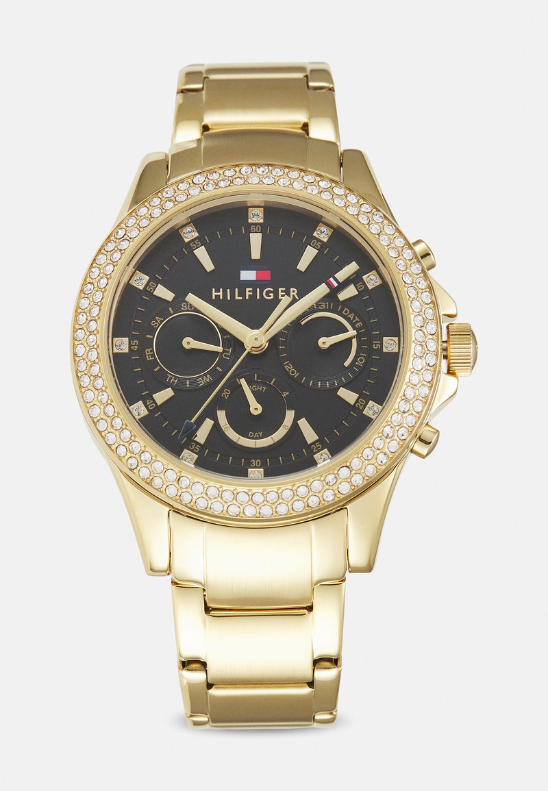 Montre en métal doré avec un cadran noir, dotée d'une lunette incrustée de cristaux, de sous-cadrans pour la date et le jour, et d'un bracelet à maillons.