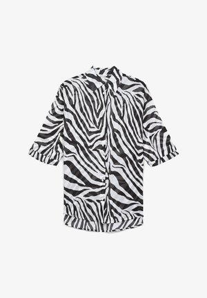 Koszula zapinana z przodu z wzorem w zebry w odcieniach czerni i bieli, krótki rękaw i kołnierzyk. Wykonana z lekkiej tkaniny.