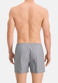 Graue Badehose mit elastischem Bund, aus leichtem Stoff gefertigt, mit einem schlichten Design und einer lockeren Passform.