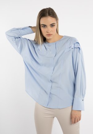 Lichtblauw shirt met een relaxte pasvorm, voorzien van een ronde halslijn, geplooide details op de schouders en knoopmanchetten. Glad stoftextuur.